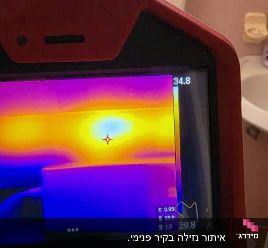 מד חום אינפרא אדום בחדר אמבטיה עם אריחים ורודים